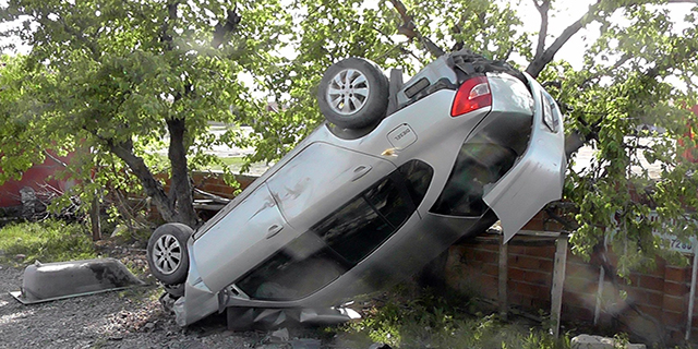 Takla atan otomobil ağaca asılı kaldı