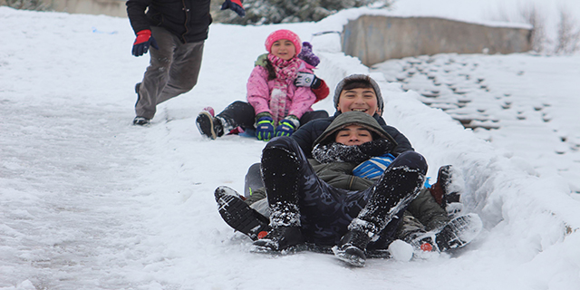 Çocuklar tepsi ve naylonlarla karda kayıp eğlendi